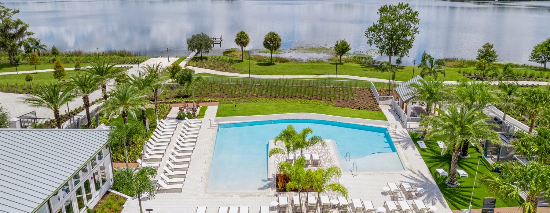 a resort style pool with seating and another body water behind it